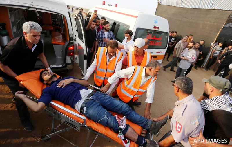 A Palestinian protester who was wounded during clashes with Israeli froces at the Israel-Gaza border, is carried on stretcher, in Khan Younis in the southern Gaza Strip on October 19, 2018. Photo by Ashraf Amra
