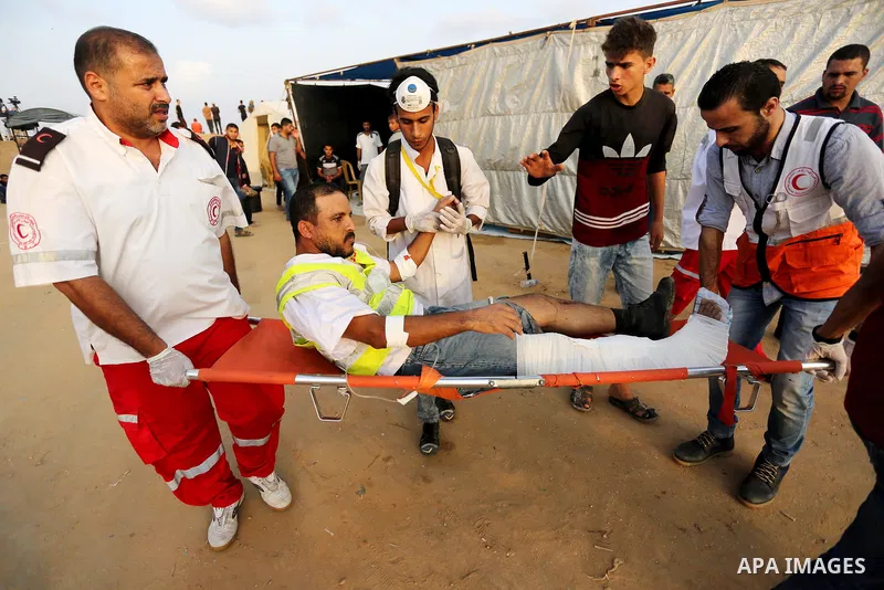 A Palestinian protester who was wounded during clashes with Israeli froces at the Israel-Gaza border, is carried on stretcher, in Khan Younis in the southern Gaza Strip on October 19, 2018. Photo by Ashraf Amra