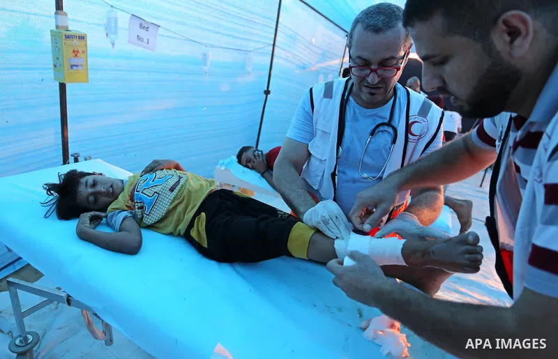 A Palestinian protester who was wounded during clashes with Israeli froces at the Israel-Gaza border, receives treatment at a medical tent, in Khan Younis in the southern Gaza Strip on October 19, 2018. Photo by Ashraf A...
