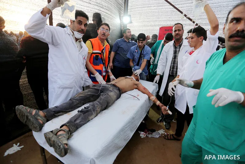 A Palestinian protester who was wounded during clashes with Israeli froces at the Israel-Gaza border, receives treatment at a medical tent, in Khan Younis in the southern Gaza Strip on October 19, 2018. Photo by Ashraf A...