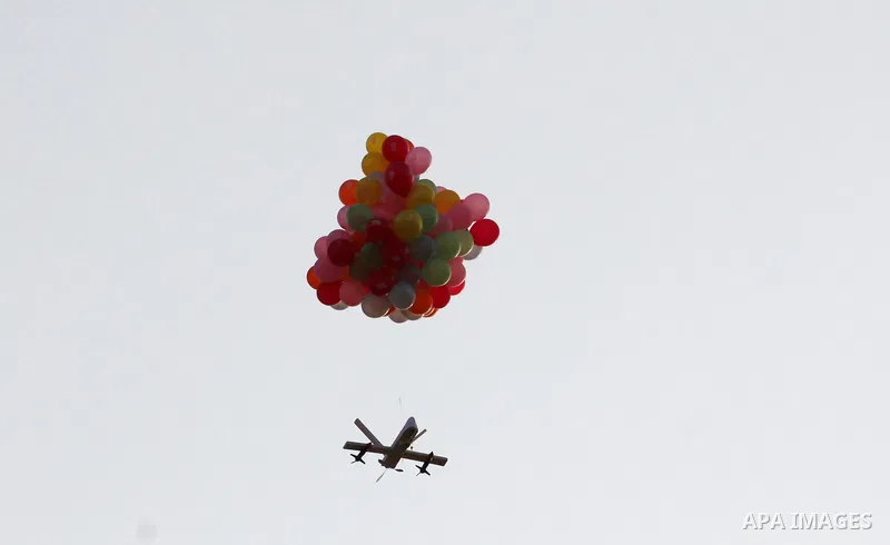 Balloons carrying flammable material are attached to a cutout of a drone as they are flown by Palestinian protesters to be sent to the Israeli side during clashes with Israeli troops in tents protest where Palestinians d...