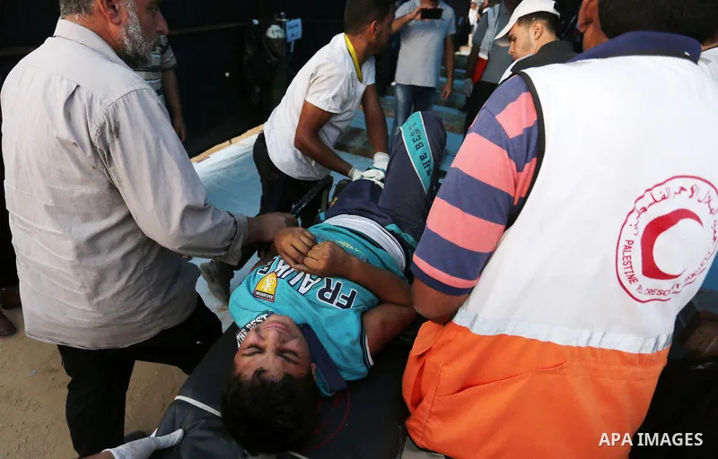 A Palestinian protester who was wounded during clashes with Israeli froces at the Israel-Gaza border, is carried on stretcher, in Khan Younis in the southern Gaza Strip on October 19, 2018. Photo by Ashraf Amra