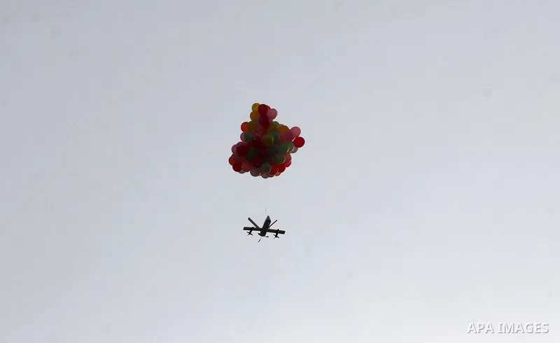 Balloons carrying flammable material are attached to a cutout of a drone as they are flown by Palestinian protesters to be sent to the Israeli side during clashes with Israeli troops in tents protest where Palestinians d...