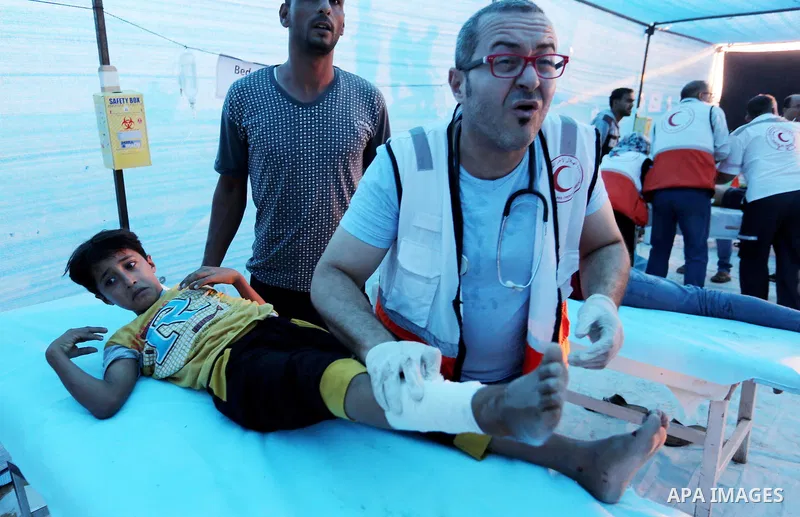 A Palestinian protester who was wounded during clashes with Israeli froces at the Israel-Gaza border, is carried on stretcher, in Khan Younis in the southern Gaza Strip on October 19, 2018. Photo by Ashraf Amra