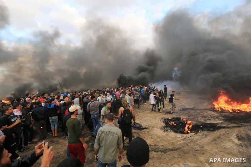 Palestinian protesters gather during clashes with Israeli troops in tents protest where Palestinians demand the right to return to their homeland at the Israel-Gaza border, in al-Bureij in the center of Gaza Strip on Oct...