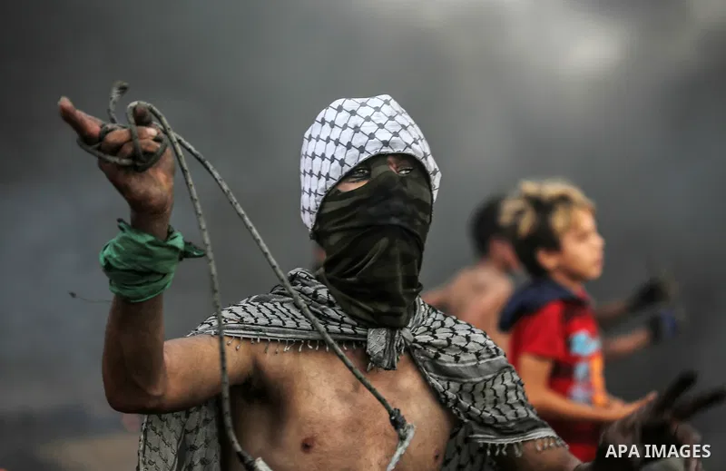 Palestinian protesters gather during clashes with Israeli troops in tents protest where Palestinians demand the right to return to their homeland at the Israel-Gaza border, in east of Gaza City on October 26, 2018. Photo...