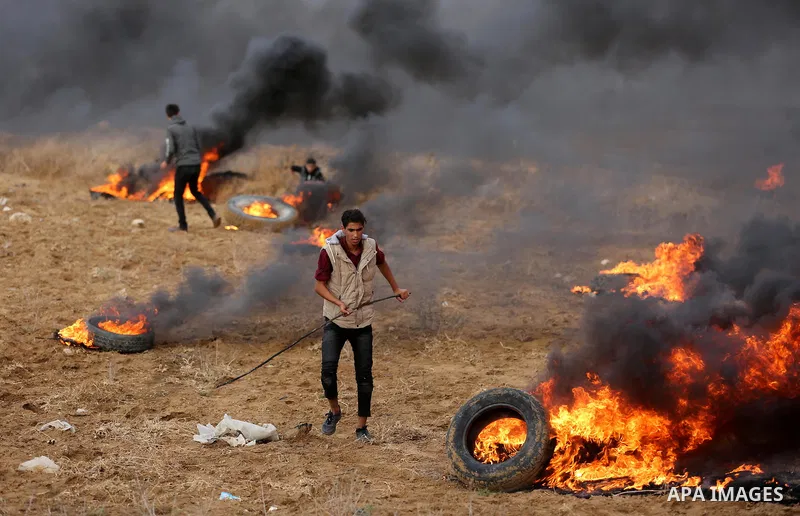 Palestinian protesters gather during clashes with Israeli troops in tents protest where Palestinians demand the right to return to their homeland at the Israel-Gaza border, in Khan Youins in the southern Gaza Strip on Oc...