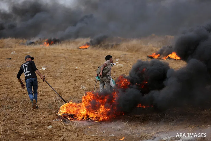 Palestinian protesters gather during clashes with Israeli troops in tents protest where Palestinians demand the right to return to their homeland at the Israel-Gaza border, in Khan Youins in the southern Gaza Strip on Oc...