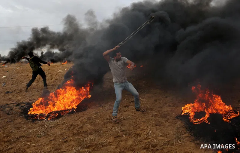 Palestinian protesters gather during clashes with Israeli troops in tents protest where Palestinians demand the right to return to their homeland at the Israel-Gaza border, in Khan Youins in the southern Gaza Strip on Oc...