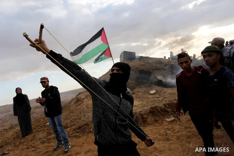 Palestinian protesters gather during clashes with Israeli troops in tents protest where Palestinians demand the right to return to their homeland at the Israel-Gaza border, in Khan Youins in the southern Gaza Strip on Oc...
