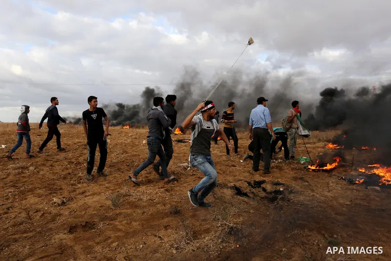 Palestinian protesters gather during clashes with Israeli troops in tents protest where Palestinians demand the right to return to their homeland at the Israel-Gaza border, in Khan Youins in the southern Gaza Strip on Oc...