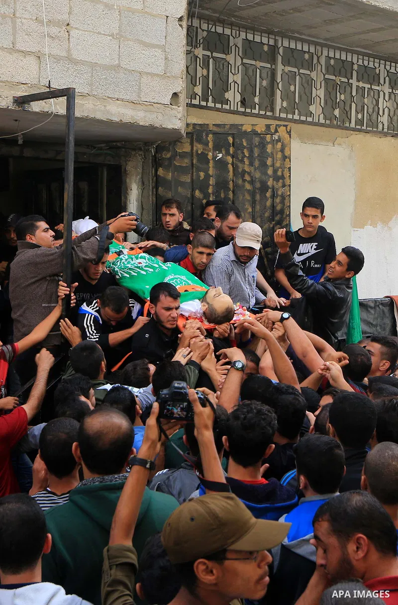 Mourners carry the body of Palestinian Mujahid Aql, 24, who was died of his wounds which he sustained by Israeli forces during clashes in tents protest where Palestinians demand the right to return to their homeland at t...