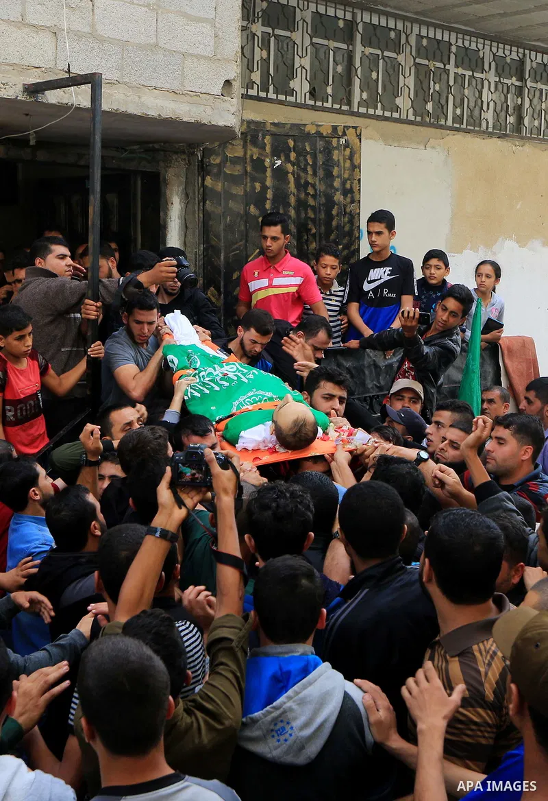 Mourners carry the body of Palestinian Mujahid Aql, 24, who was died of his wounds which he sustained by Israeli forces during clashes in tents protest where Palestinians demand the right to return to their homeland at t...