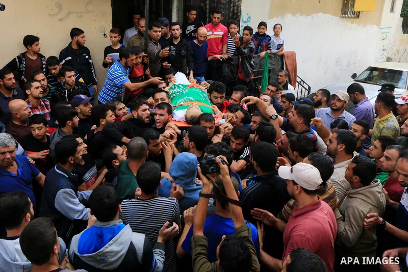 Mourners carry the body of Palestinian Mujahid Aql, 24, who was died of his wounds which he sustained by Israeli forces during clashes in tents protest where Palestinians demand the right to return to their homeland at t...