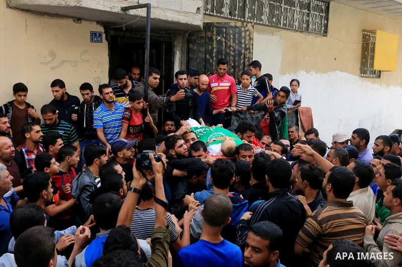 Mourners carry the body of Palestinian Mujahid Aql, 24, who was died of his wounds which he sustained by Israeli forces during clashes in tents protest where Palestinians demand the right to return to their homeland at t...