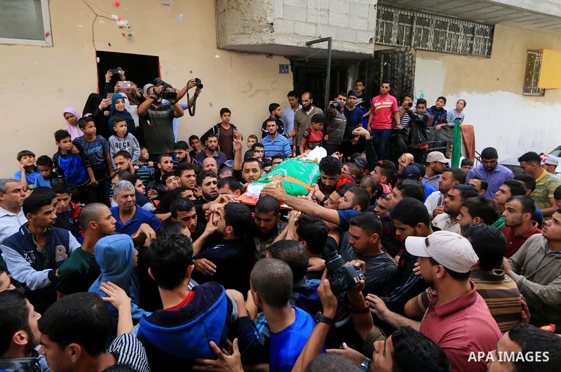Mourners carry the body of Palestinian Mujahid Aql, 24, who was died of his wounds which he sustained by Israeli forces during clashes in tents protest where Palestinians demand the right to return to their homeland at t...