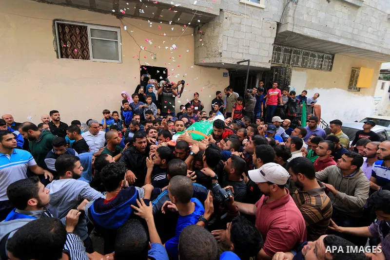 Mourners carry the body of Palestinian Mujahid Aql, 24, who was died of his wounds which he sustained by Israeli forces during clashes in tents protest where Palestinians demand the right to return to their homeland at t...