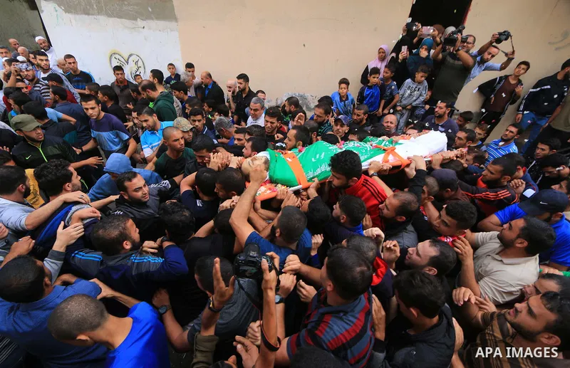 Mourners carry the body of Palestinian Mujahid Aql, 24, who was died of his wounds which he sustained by Israeli forces during clashes in tents protest where Palestinians demand the right to return to their homeland at t...