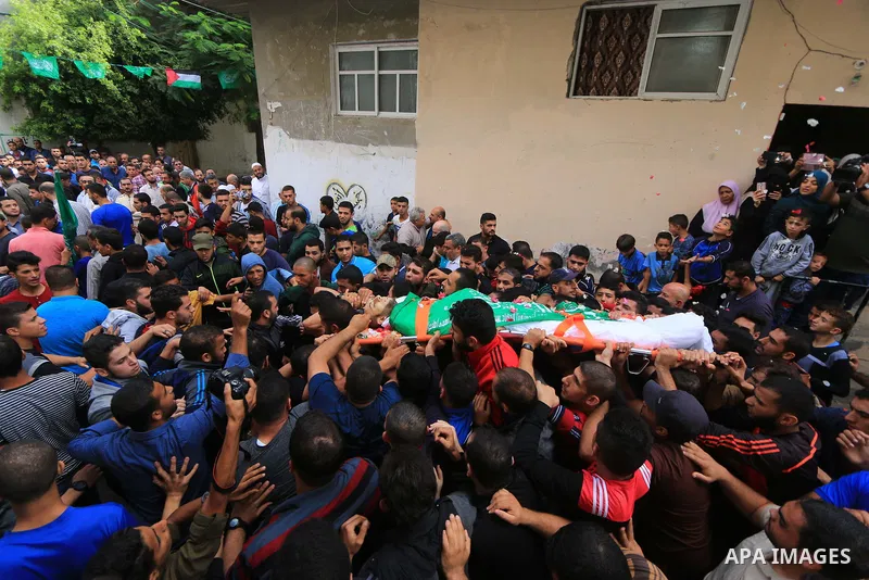 Mourners carry the body of Palestinian Mujahid Aql, 24, who was died of his wounds which he sustained by Israeli forces during clashes in tents protest where Palestinians demand the right to return to their homeland at t...