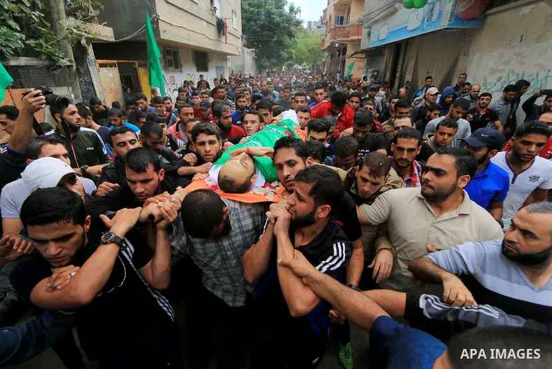 Mourners carry the body of Palestinian Mujahid Aql, 24, who was died of his wounds which he sustained by Israeli forces during clashes in tents protest where Palestinians demand the right to return to their homeland at t...