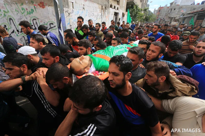 Mourners carry the body of Palestinian Mujahid Aql, 24, who was died of his wounds which he sustained by Israeli forces during clashes in tents protest where Palestinians demand the right to return to their homeland at t...