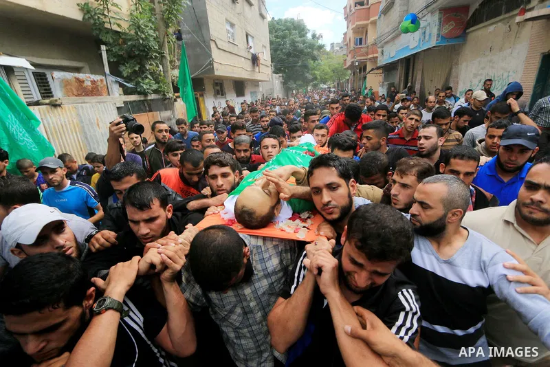 Mourners carry the body of Palestinian Mujahid Aql, 24, who was died of his wounds which he sustained by Israeli forces during clashes in tents protest where Palestinians demand the right to return to their homeland at t...