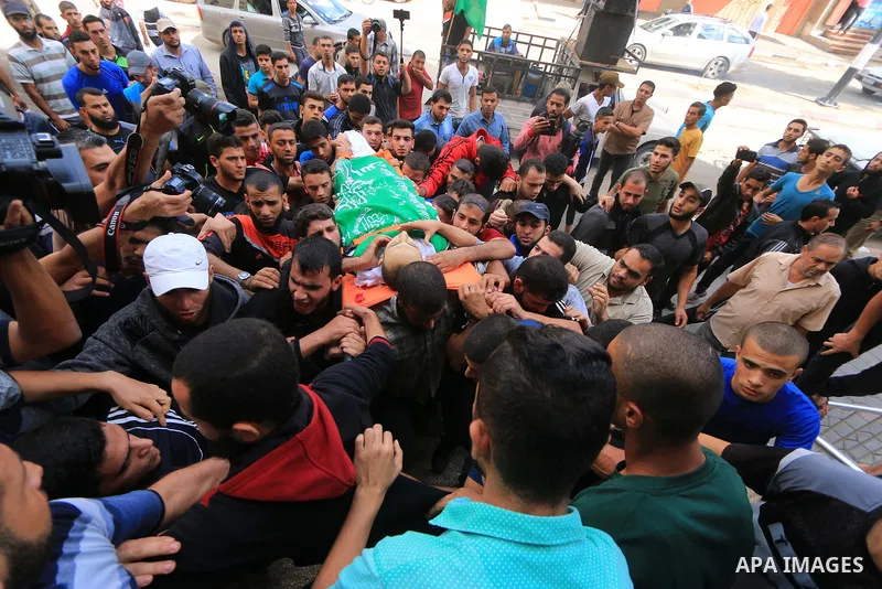 Mourners carry the body of Palestinian Mujahid Aql, 24, who was died of his wounds which he sustained by Israeli forces during clashes in tents protest where Palestinians demand the right to return to their homeland at t...