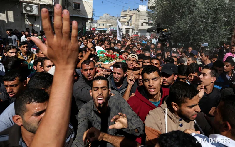 Mourners carry the body of Palestinian Ahmed Abu Lebda, 22, who was shot dead by Israeli forces during clashes in tents protest where Palestinians demand the right to return to their homeland at the Israel-Gaza border, d...