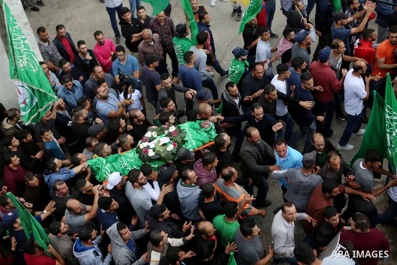 Mourners carry the body of Palestinian Othman Ladadwah, who was shot dead by Israeli forces during clashes the day before, during his funeral in the village of Al-Mazraa Al-Gharbeya, in the West Bank city of Ramallah on...