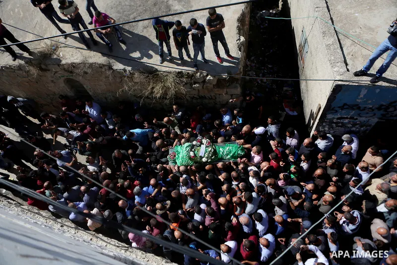 Mourners carry the body of Palestinian Othman Ladadwah, who was shot dead by Israeli forces during clashes the day before, during his funeral in the village of Al-Mazraa Al-Gharbeya, in the West Bank city of Ramallah on...