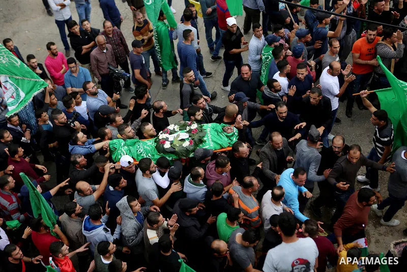 Mourners carry the body of Palestinian Othman Ladadwah, who was shot dead by Israeli forces during clashes the day before, during his funeral in the village of Al-Mazraa Al-Gharbeya, in the West Bank city of Ramallah on...