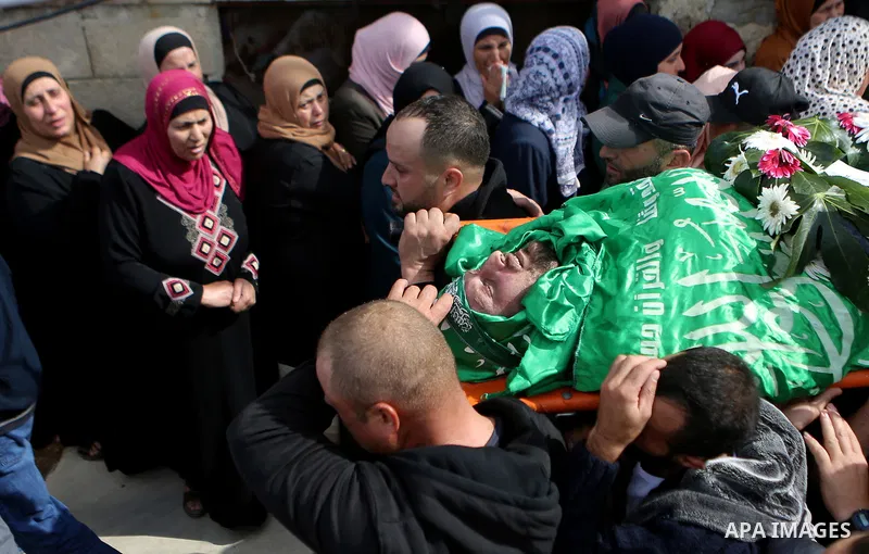 Mourners carry the body of Palestinian Othman Ladadwah, who was shot dead by Israeli forces during clashes the day before, during his funeral in the village of Al-Mazraa Al-Gharbeya, in the West Bank city of Ramallah on...