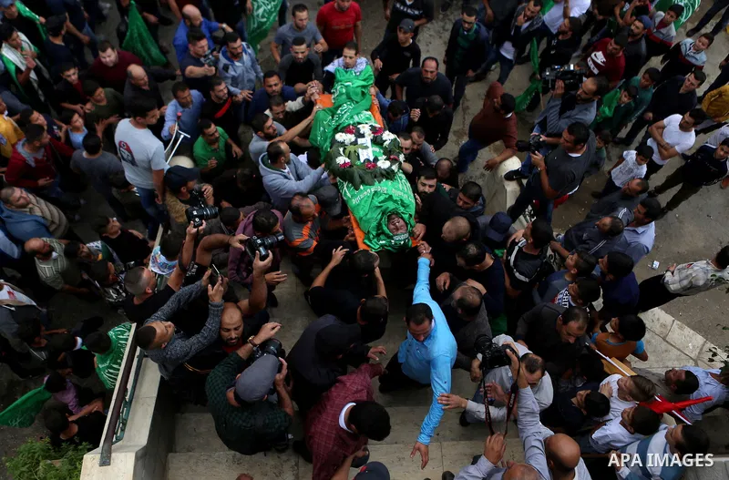 Mourners carry the body of Palestinian Othman Ladadwah, who was shot dead by Israeli forces during clashes the day before, during his funeral in the village of Al-Mazraa Al-Gharbeya, in the West Bank city of Ramallah on...