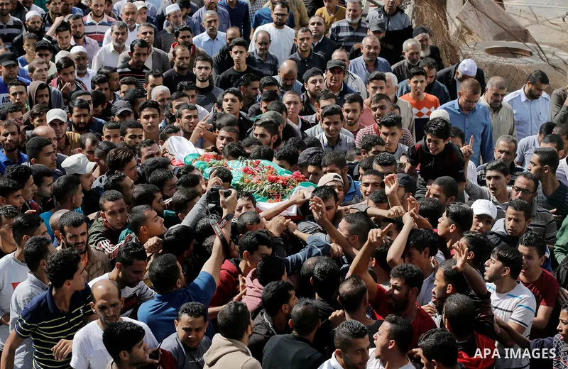 Mourners carry the body of Palestinian Ahmed Abu Lebda, 22, who was shot dead by Israeli forces during clashes in tents protest where Palestinians demand the right to return to their homeland at the Israel-Gaza border, d...