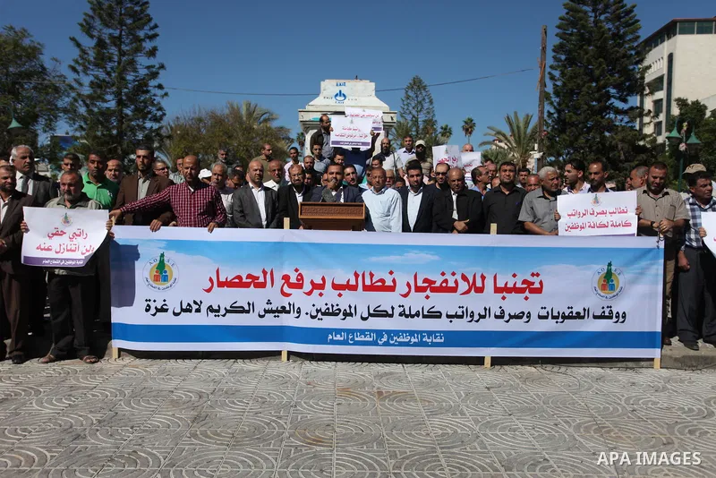 Palestinian employees of Gaza strip hold banners during a protest demanding their salaries, in Gaza city on October 28, 2018. Photo by Mahmoud Ajjour