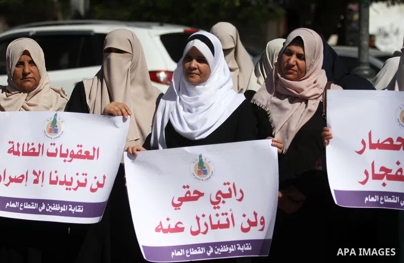 Palestinian employees of Gaza strip hold banners during a protest demanding their salaries, in Gaza city on October 28, 2018. Photo by Mahmoud Ajjour