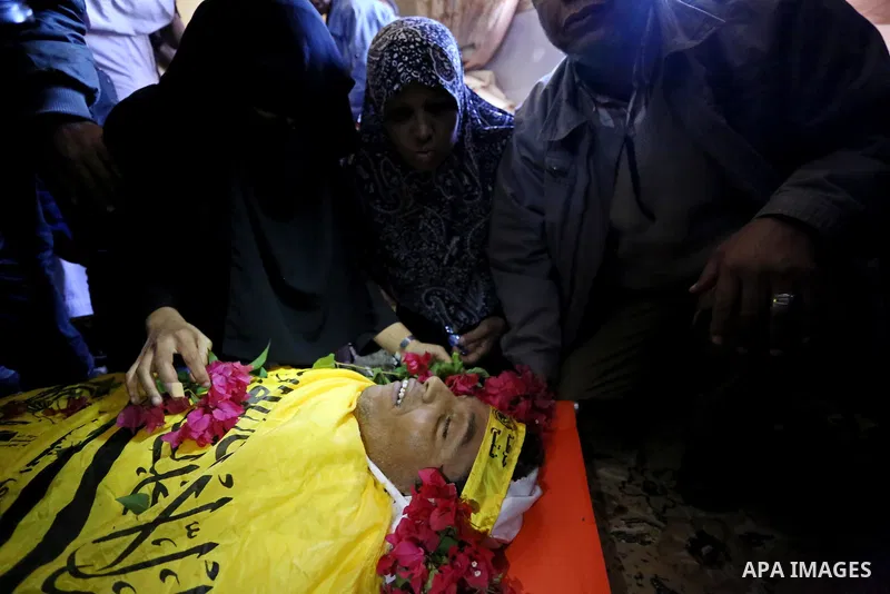 Relatives of Palestinian Yahya el-Hassanat, 37, who was shot dead by Israeli troops during clashes in tents protest where Palestinian demand rights to return to their homeland at Israel-Gaza border, mourn over his body d...