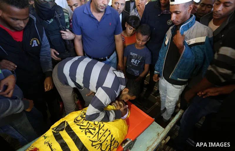 Relatives of Palestinian Yahya el-Hassanat, 37, who was shot dead by Israeli troops during clashes in tents protest where Palestinian demand rights to return to their homeland at Israel-Gaza border, mourn over his body d...