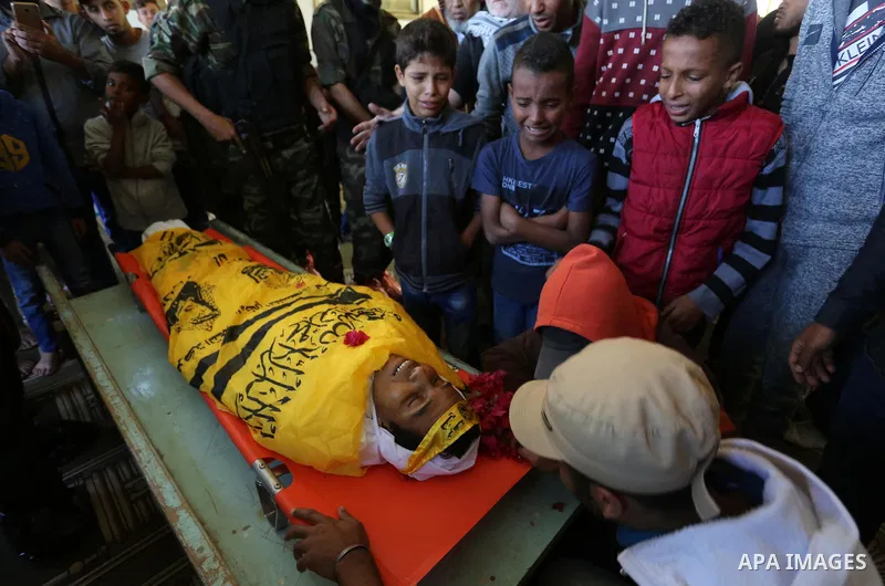 Relatives of Palestinian Yahya el-Hassanat, 37, who was shot dead by Israeli troops during clashes in tents protest where Palestinian demand rights to return to their homeland at Israel-Gaza border, mourn over his body d...