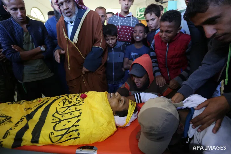 Relatives of Palestinian Yahya el-Hassanat, 37, who was shot dead by Israeli troops during clashes in tents protest where Palestinian demand rights to return to their homeland at Israel-Gaza border, mourn over his body d...