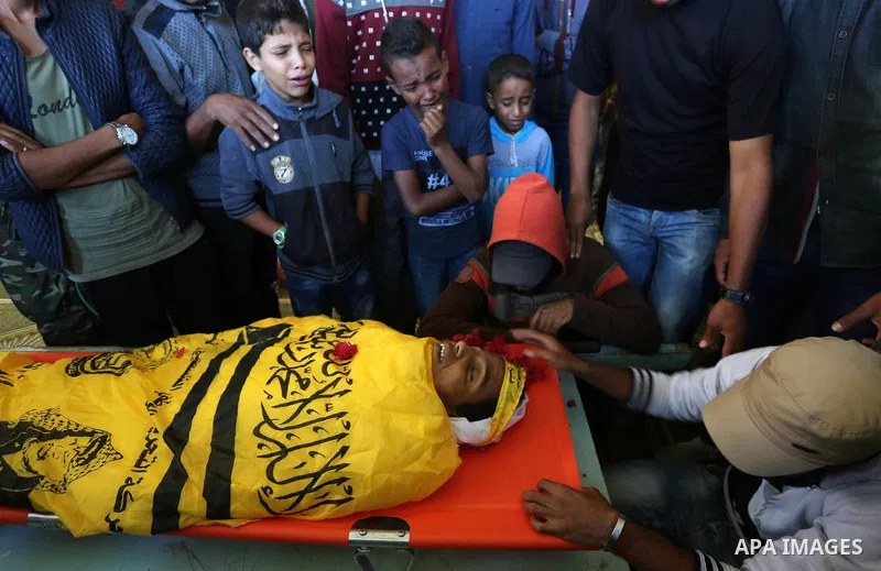 Relatives of Palestinian Yahya el-Hassanat, 37, who was shot dead by Israeli troops during clashes in tents protest where Palestinian demand rights to return to their homeland at Israel-Gaza border, mourn over his body d...