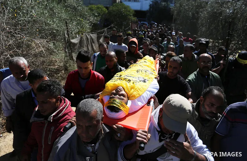 Mourners carry the body of Palestinian Yahya el-Hassanat, 37, who was shot dead by Israeli troops during clashes in tents protest where Palestinian demand rights to return to their homeland at Israel-Gaza border, during...