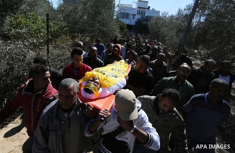 Mourners carry the body of Palestinian Yahya el-Hassanat, 37, who was shot dead by Israeli troops during clashes in tents protest where Palestinian demand rights to return to their homeland at Israel-Gaza border, during...