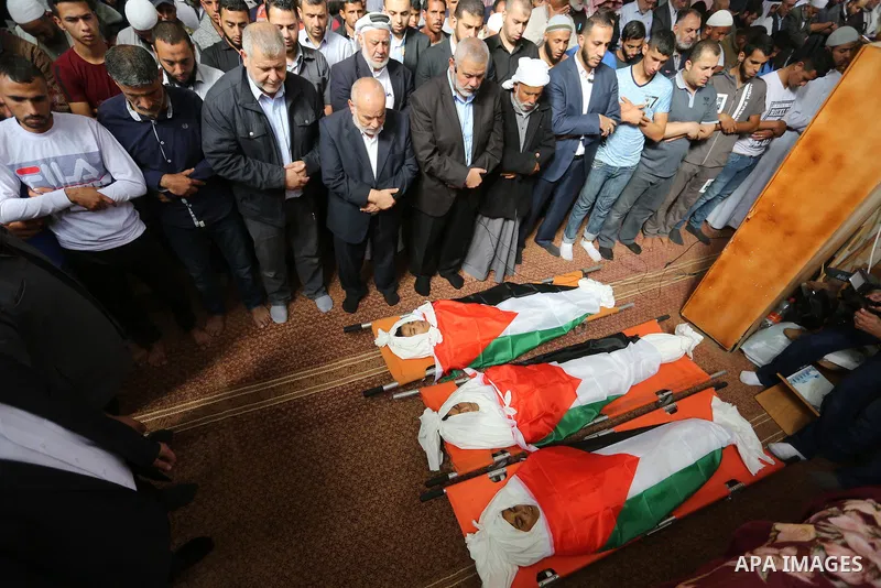 Palestinian Hamas Chief Ismail Haniyeh prays over the bodies of three Palestinian teenagers who were killed in an Israeli air strike on the Gaza Strip during their funeral in Deir el-Balah in central of the Gaza Strip on...