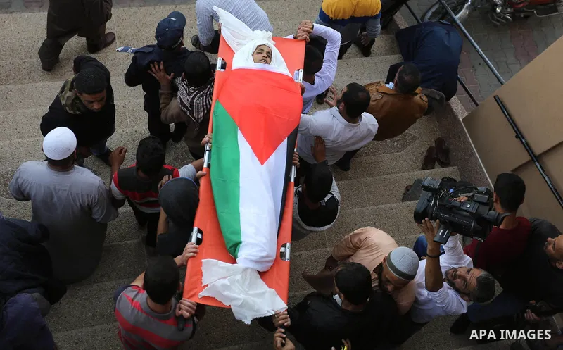 Palestinian mourners carry the bodies of three Palestinian teenagers who were killed in an Israeli air strike on the Gaza Strip during their funeral in Deir el-Balah in central of the Gaza Strip on October 29, 2018. Phot...