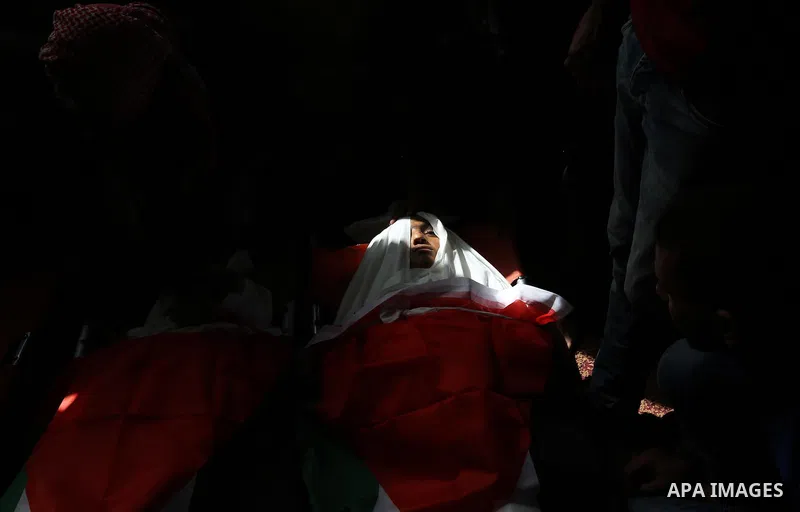 Palestinian mourners gather around the bodies of three Palestinian teenagers who were killed in an Israeli air strike on the Gaza Strip during their funeral in Deir el-Balah in central of the Gaza Strip on October 29, 20...