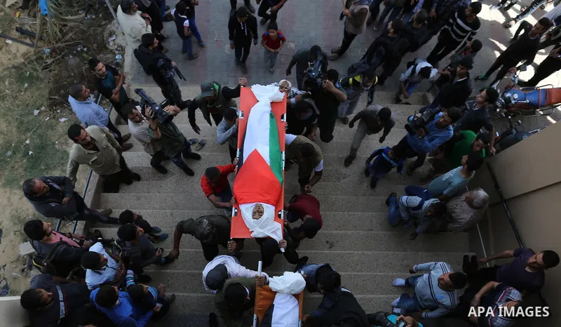 Palestinian mourners carry the bodies of three Palestinian teenagers who were killed in an Israeli air strike on the Gaza Strip during their funeral in Deir el-Balah in central of the Gaza Strip on October 29, 2018. Phot...