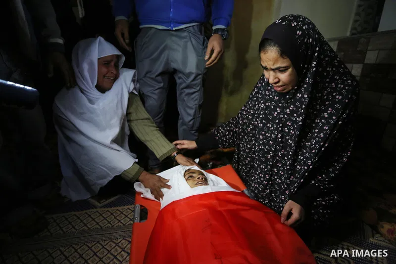 Relatives of Palestinian teenager Khaled Saed, who was killed in an Israeli air strike on the Gaza Strip , mourn over his body during his funeral in Deir el-Balah in central of the Gaza Strip on October 29, 2018. Photo b...