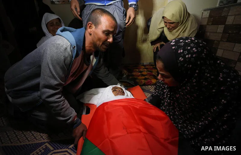 Relatives of Palestinian teenager Khaled Saed, who was killed in an Israeli air strike on the Gaza Strip , mourn over his body during his funeral in Deir el-Balah in central of the Gaza Strip on October 29, 2018. Photo b...