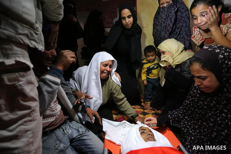 Relatives of Palestinian teenager Khaled Saed, who was killed in an Israeli air strike on the Gaza Strip , mourn over his body during his funeral in Deir el-Balah in central of the Gaza Strip on October 29, 2018. Photo b...